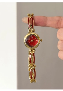 Detail of GEDI gold alloy bracelet watch with red mother-of-pearl dial and enamel inlay