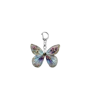 Detail of acrylic butterfly keychain with blue wings and floral patterns and silver clasp