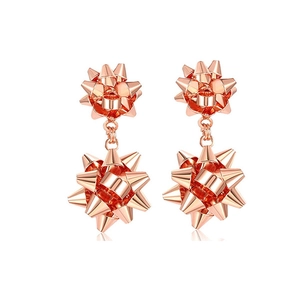 Detailed view of rose gold long floral earrings with metallic bow gift design