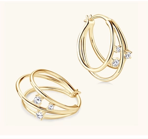 Macro detail of triple-layer gold interlocking hoop earrings with zircon stones