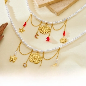 Close-up of pearl chain necklace with vintage sun, moon, and heart charms in gold
