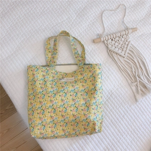 Détail du sac cabas en toile jaune à fleurs avec étiquette Natural patterns et coton doux