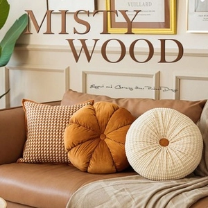 Close-up of luxury embroidered pillows featuring houndstooth and orange velvet pumpkin design