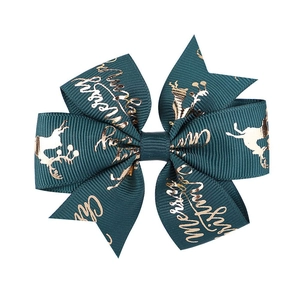 Close-up of green grosgrain ribbon bow with gold reindeer and Merry Christmas print