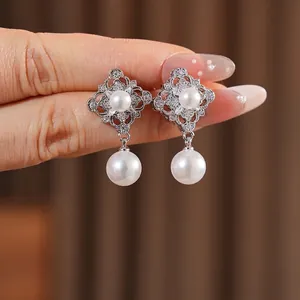 Vintage palace style pearl drop earrings with silver hollow design and sparkling zircons