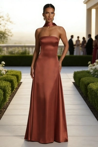 Detail of elegant cinnamon satin maxi dress showing backless design and cowl neck scarf accessory