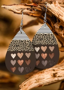 Detail of teardrop leather earrings with leopard print and heart patterns on wood