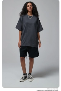 Close-up of oversized dark gray cotton t-shirt with drop shoulder design on a model