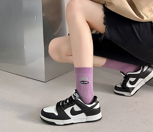 Detailed view of purple cotton mid-tube socks with est. 2010 embroidery and ribbed texture
