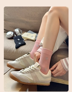 Detail of pink cotton mid-calf socks with silver star embroidery and ribbed cuffs