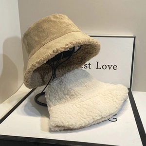 Detail view of khaki faux suede and white plush bucket hats on display stands