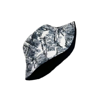 Detail of reversible bucket hat featuring black ink graffiti and handwritten quote