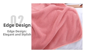Detail of pink coral fleece bath towel showing durable hemmed edges and waffle texture