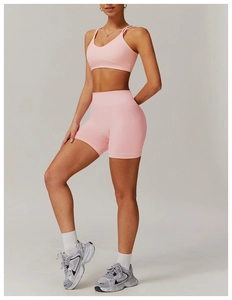 Detail of pink seamless yoga set with double-strap sports bra and high-waisted shorts