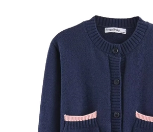 Détail du cardigan bleu marine avec poches contrastées roses et col rond ajusté