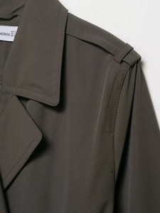 Close-up of olive green double-breasted coat showing woven fabric texture and neckline details