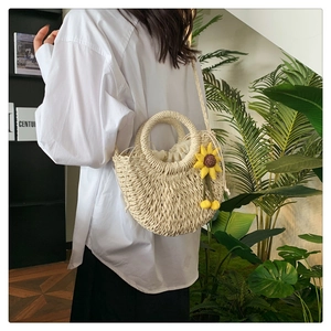Detailaufnahme der handgefertigten Strohtasche mit gelbem Sonnenblumen-Accessoire