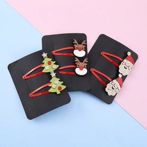Set di fermagli natalizi con renna, Babbo Natale e albero glitterati su sfondo rosa