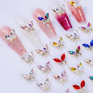 Macro shot of 3D butterfly nail charms with aurora rhinestones and faux pearls for DIY art