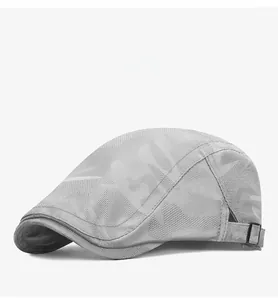 Detail of grey camo mesh flat cap showing breathable fabric and black metal side buckle