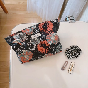 Floral makeup bag with accessories including leopard hair tie and matte hair clips