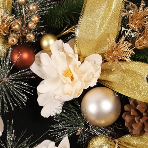 Christmas wreath with gold ribbons, cream flowers, pine cones and snow pine needles