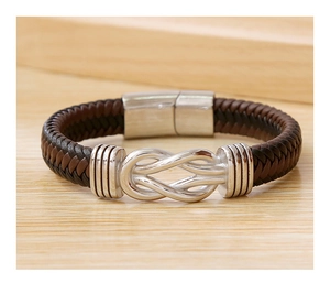 Detailed view of brown braided leather bracelet with a silver knot metal accent