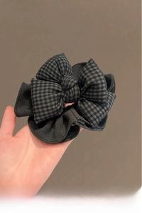 Détail d'un chouchou à carreaux noirs et gris avec un design de nœud élégant