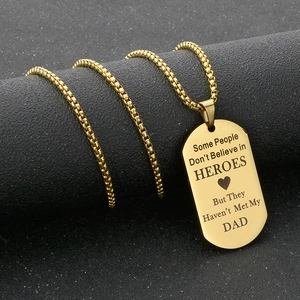 Macro detail of gold dog tag pendant with Dad heroes quote and polished metal finish