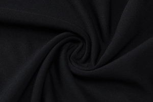 Macro shot of premium black knitted fabric texture with elegant spiral pleated details
