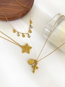Detail of gold titanium necklaces with cross, star, and religious medal pendants