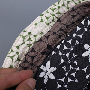 Détail de chapeaux bob matelassés à motifs floraux montrant la texture du tissu