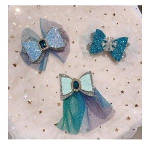 Detail of glitter bow hair clips with blue gems and mesh lace in frozen princess style