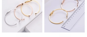 Detailed view of rhinestone dolphin tail open bangles in silver, gold, and rose gold finishes