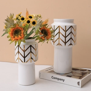 Modern white ceramic flower vases with golden V-shaped geometry and sunflower accents