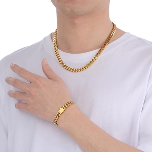 Polished gold Miami Cuban link chain necklace and bracelet set worn by a male model