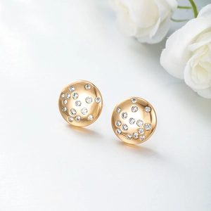 Elegant gold round stud earrings with shimmering zircon crystals on white rose background