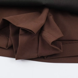 Nahaufnahme von kaffeebraunem Köperstoff mit hochwertigen Nähten und Texturdetails