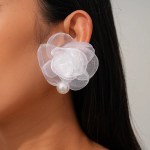 Gros plan de boucles d'oreilles fleur en tissu blanc avec résille et perle élégante