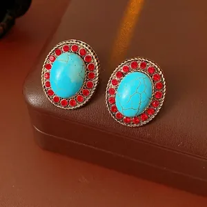 Vintage-Ohrstecker in Ovalform mit blauem Stein und roten Kristallen auf Lederbox