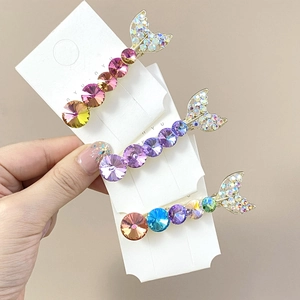 Detailed close-up of mermaid tail hair clips with colorful K9 crystals and rhinestones