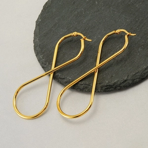 Minimalist 18k gold plated stainless steel infinity loop earrings on black slate