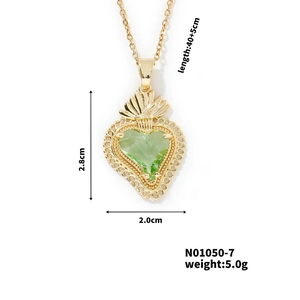 Macro detail of gold heart pendant with green gemstone and size specifications