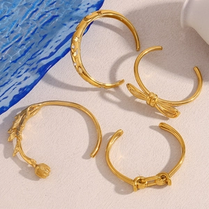 Set of four 18K gold plated stainless steel open bangles with rose and butterfly motifs