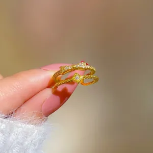 Detail of gold plated bow ring with pave zircon stones and twisted band with square crystal