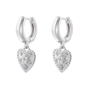 Detailed macro view of heart-shaped pearl and zircon inlay on silver C-shaped hoop earrings