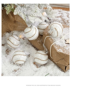 Detail of white glitter Christmas balls with brown spirals on artificial snow