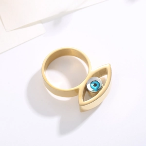 Makroaufnahme des goldenen Edelstahlrings mit blauem Teufelsauge aus Kunstharz