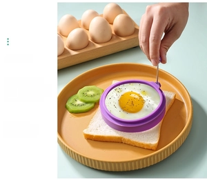 Purple silicone round fried egg mold with stainless steel handle on a kitchen table