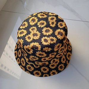 Macro shot of black bucket hat with vibrant yellow sunflower floral pattern design